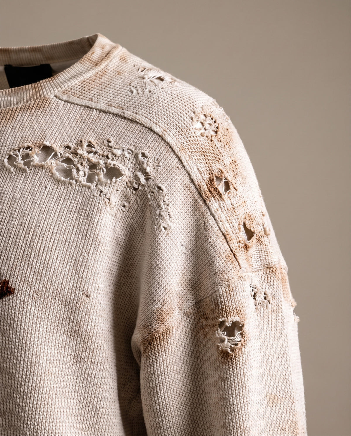 Close-up of the distressed shoulder holes and rusty acid-wash staining